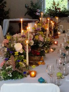 Centrotavola floreale con candele alte e fiori di campo per matrimonio a Villa Gioia, allestimento di DV Flowers
